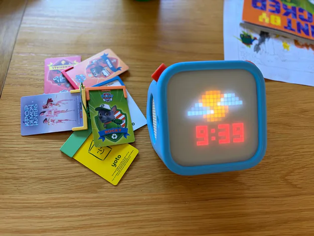 Our Yoto Player 3rd Generation in its blue Adventure Jacket beside cards on a keychain
