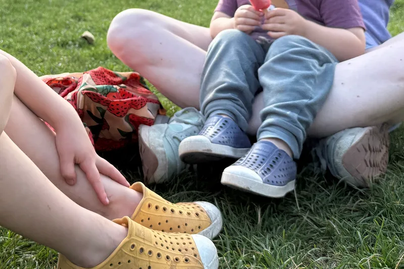 Yellow and light blue Native Jefferson shoes worn on grass