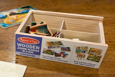 Our Melissa & Doug Dinosaurs four-puzzle wooden box with divided storage and 12-piece labeling