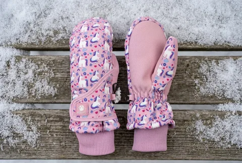 N'Ice Caps kids snow mittens lying flat on a snow-dusted wooden bench
