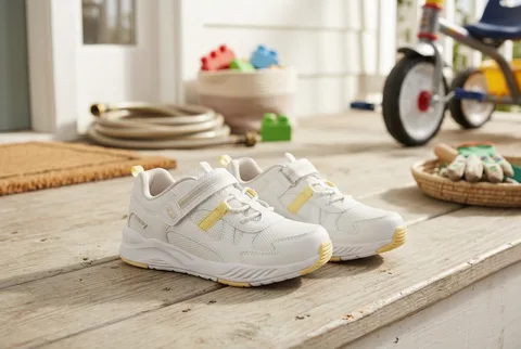 Stride Rite Made2Play Player off-white sneakers on an entryway mat