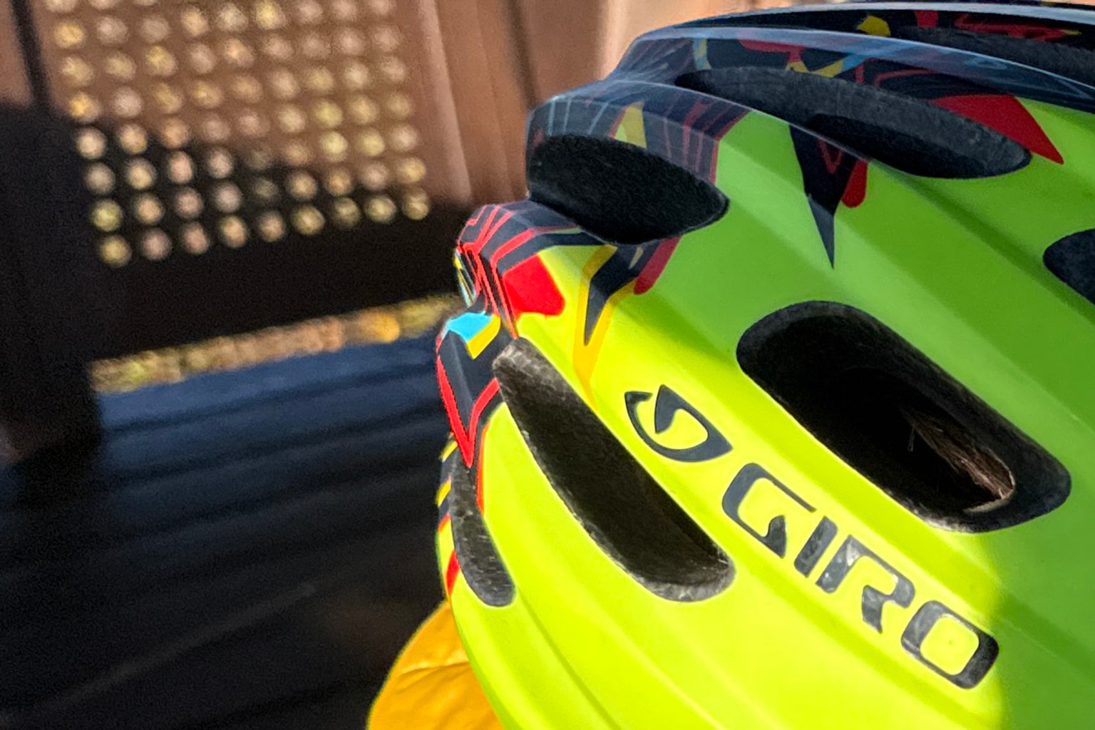 Close owner photo of the larger visored bright-green Giro Hale MIPS against a shaded metal shelter